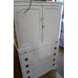 A DISTRESSED PAINTED SIDE CABINET having plain panelled cupboard doors over brushing slide and