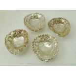 G**C** A SET OF FOUR VICTORIAN SILVER PIN DISHES, each of heart form, pressed with flowers,