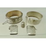 A COLLECTION OF FIVE SILVER ITEMS, two decoratively engraved vestas, two chased bracelets and a