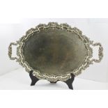 A SILVER-PLATED TWO HANDLED TEA TRAY of oval form with cast scallop rim, handles and feet, overall