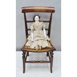 A VICTORIAN DOLL having glazed ceramic head, forearms and lower legs with moulded black boots,