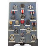 A COLLECTION OF SEVENTEEN GERMAN MILITARY MEDALS, mounted upon a board, some with ribbons, to