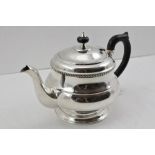 HAMILTON AND CO., CALCUTTA A WHITE METAL TEAPOT with hinged cover and ebonised handle, stamped "