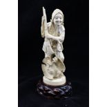 A JAPANESE MEIJI PERIOD CARVED IVORY FIGURE, An Eagle hunter, with prey and matchlock rifle, 18cm
