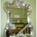 A ROCOCO DESIGN SILVER FRAMED WALL MIRROR