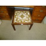 A SMALL TILE TOP TABLE