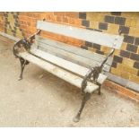 A BLACK PAINTED CAST IRON ENDED GARDEN BENCH with painted wooden slats