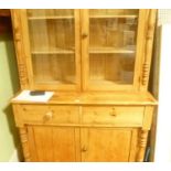 A PROBABLE LATE 19TH CENTURY PINE BOOKCASE/ DRESSER having two plain glazed cupboard doors opening