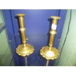 A PAIR OF PROBABLE 18TH CENTURY BRASS EJECTOR CANDLESTICKS on spun flower head base