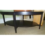 A BLACK ASH FRAMED OVAL INSERT GLASS TOPPED COFFEE TABLE with solid magazine undertier