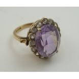 AN AMETHYST DRESS RING, having facet cut oval stone, in a 9ct gold setting, ring size "N"