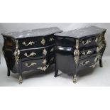 A PAIR OF LOUIS XV STYLE EBONISED COMMODES OF BOMBE FORM with polished veined stone tops, ornate