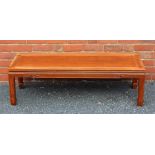 A 20TH CENTURY ORIENTAL DESIGN LONG AND LOW RECTANGULAR TOPPED COFFEE TABLE supported on four