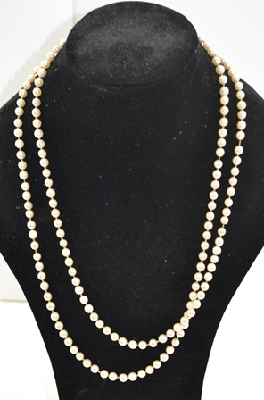 A LONG SINGLE STRAND OF CULTURED PEARLS, 0.6mm with yellow metal clasp, 128cm long
