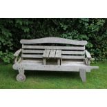 A TEAK SLAT FORM MOBILE GARDEN SEAT BENCH FOR TWO with central table, bearing the makers name '