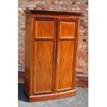 A "MAPLE & CO." MAHOGANY BOW FRONTED TWO DOOR WARDROBE with dentil cornice, the panelled doors