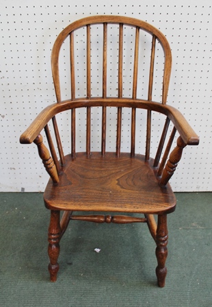 A CHILD'S PROVINCIAL WINDSOR STICK BACK ARMCHAIR, having elm seat, on ring turned supports united