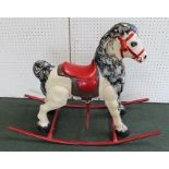 A TIN-PLATE ROCKING HORSE, painted dapple grey, on red tube rockers with handle bars and