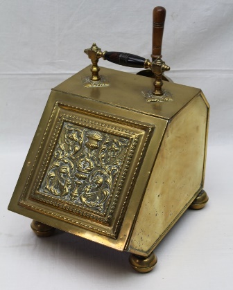 AN EDWARDIAN BRASS COAL PURDONIUM, the embossed hinged front panel reveals an interior liner, with