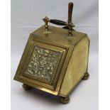 AN EDWARDIAN BRASS COAL PURDONIUM, the embossed hinged front panel reveals an interior liner, with