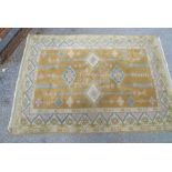 A 20TH CENTURY PERSIAN DESIGN RUG, golden field with lozenge and spiral column decoration in blue