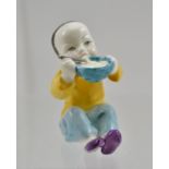 A ROYAL WORCESTER BONE CHINA FIGURINE "China", a child eating from a bowl, seated on the ground,