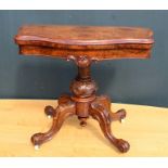 A 19TH CENTURY WALNUT VENEER SERPENTINE FRONTED FOLDOVER CARD TABLE, having carved stem and four