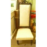 A 19TH CENTURY HIGH BACKED EBONISED WOODEN FRAMED LOW CHAIR with gold damask back and seat pads,