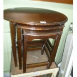 A MODERN MAHOGANY FINISHED OVAL TOP NEST OF THREE TABLES