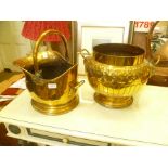 A BRASS SWING HANDLED COAL SCUTTLE together with A TWIN HANDLED PEDESTAL PLANTER with embossed