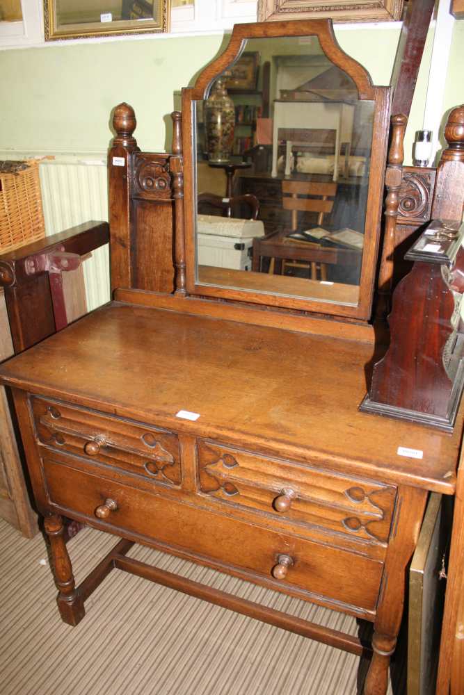 A CARVED OAK SINGLE BED HEAD AND FOOT BOARD with metal side rails, together with A DRESSING TABLE