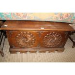 A 20TH CENTURY OAK FINISHED BLANKET CHEST having decoratively carved front