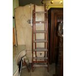 A VINTAGE SET OF WOODEN EXTENDING LADDERS