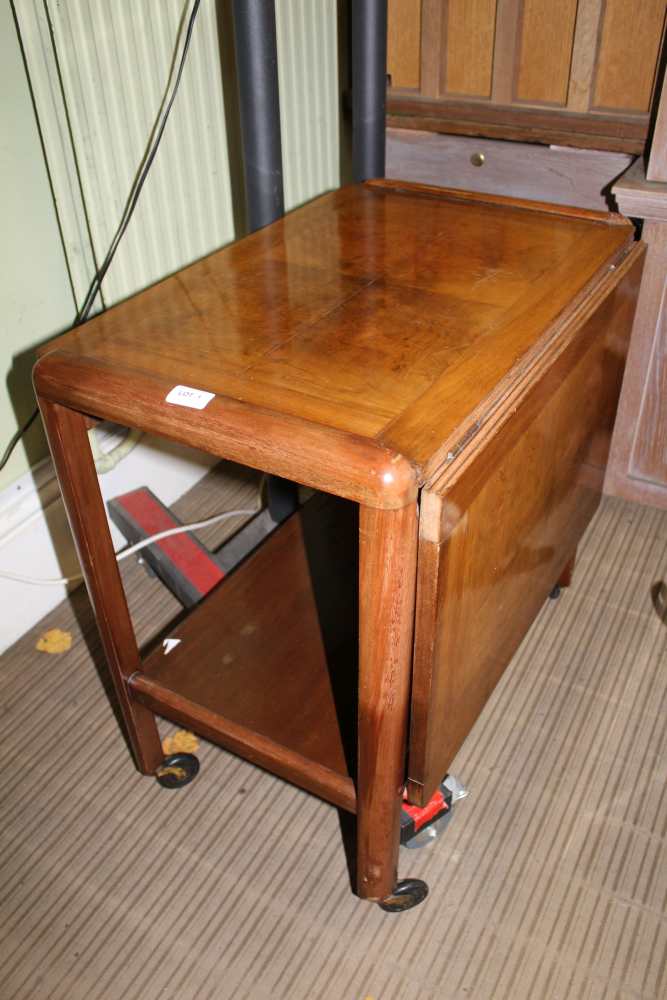 AN MID 20TH CENTURY WALNUT FINISHED METAMORPHIC TEA TROLLEY, having slide out double width top, over
