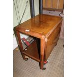 AN MID 20TH CENTURY WALNUT FINISHED METAMORPHIC TEA TROLLEY, having slide out double width top, over