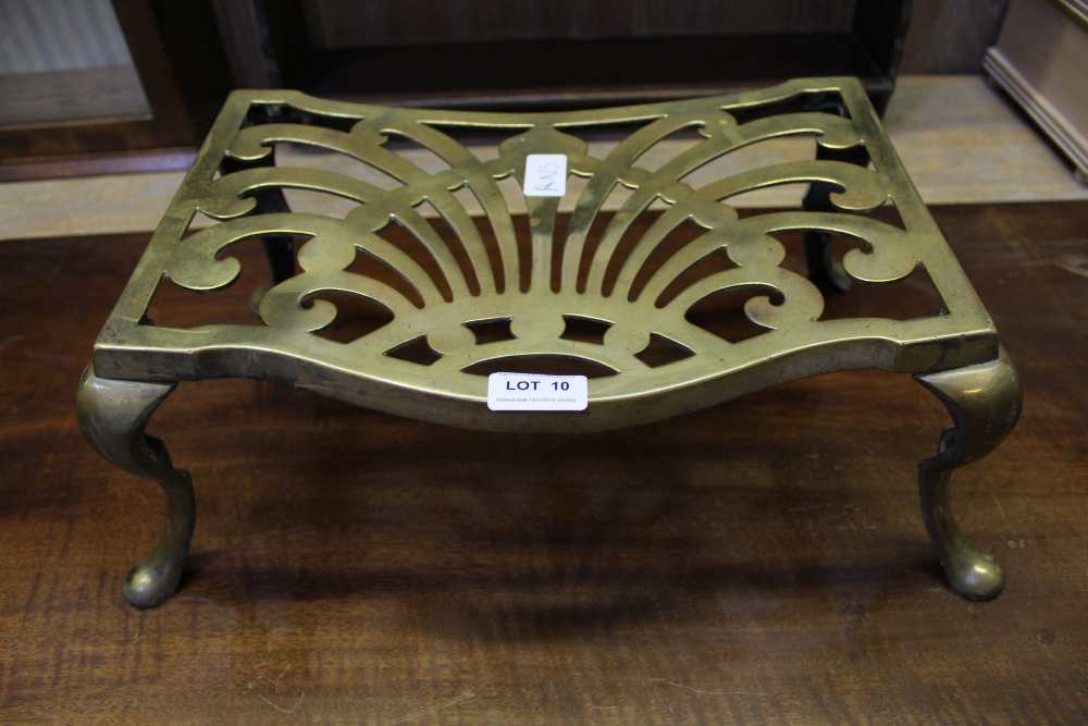 A PIERCED BRASS LOW TRIVET on four cabriole legs