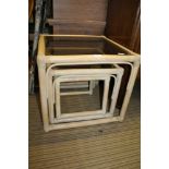A NEST OF THREE BAMBOO FRAMED TABLES with smoked glass tops