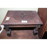 A SMALL CARVED RECTANGULAR TOPPED STOOL