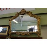 A FANCY GILT FRAMED SHAPED PLAIN PLATE OVER MANTLE