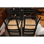 THREE BLACK FINISHED SINGLE CHAIRS with woven rush seats