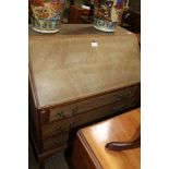 A 20TH CENTURY MAHOGANY FINISHED BUREAU having fall down writing slope over three full width drawers