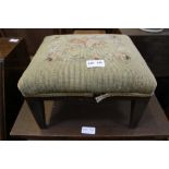 A SMALL WOODEN FRAMED FOUR LEGGED STOOL with wool work pad top