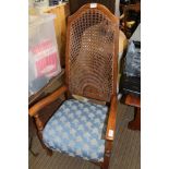 A MID 20TH CENTURY HIGH BERGERE BACKED ARMCHAIR with over stuffed seat pad