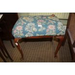 A FLORAL DESIGN UPHOLSTERED RECTANGULAR PAD TOP STOOL on cabriole legs