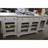 A PROBABLE PINE SHABBY CHIC PAINTED BREAK FRONT SIDE UNIT with four inline drawers over four plain