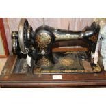 A WOODEN CASED JONES BRANDED FAMILY MANUAL SEWING MACHINE