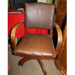 A MID-CENTURY OAK FRAMED ADJUSTABLE OFFICE ARMCHAIR, with brown Rexine back and seat pad,