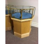 A hexagonal brass trim glazed top display cabinet on beach base. Height 90cm.