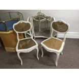 A French style beveled edge white painted free standing mirror with two white painted chairs.