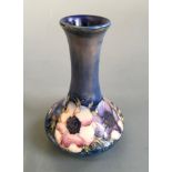 A Moorcroft vase on dark blue background in anemome design. Height approximately 15cm.